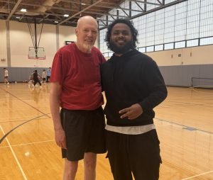 Godfrey poses next to Milroy Stanislaus, who was one of his new teammates during a pickup game. 