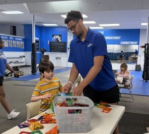 Carlos’ son, James Tearney, works alongside one of the children in the program.